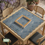 Blue mahjong mat with a botanical floral pattern, pale leaves, and delicate stems on a dusty blue background.
