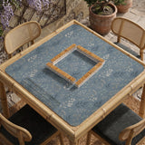 Blue mahjong mat with a botanical floral pattern, pale leaves, and delicate stems on a dusty blue background.