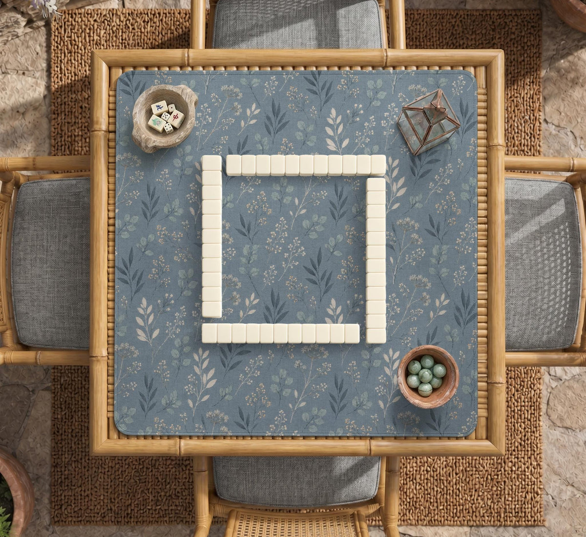 Blue mahjong mat with a dusty linen-look background and small leafy botanical stems in a floral pattern.