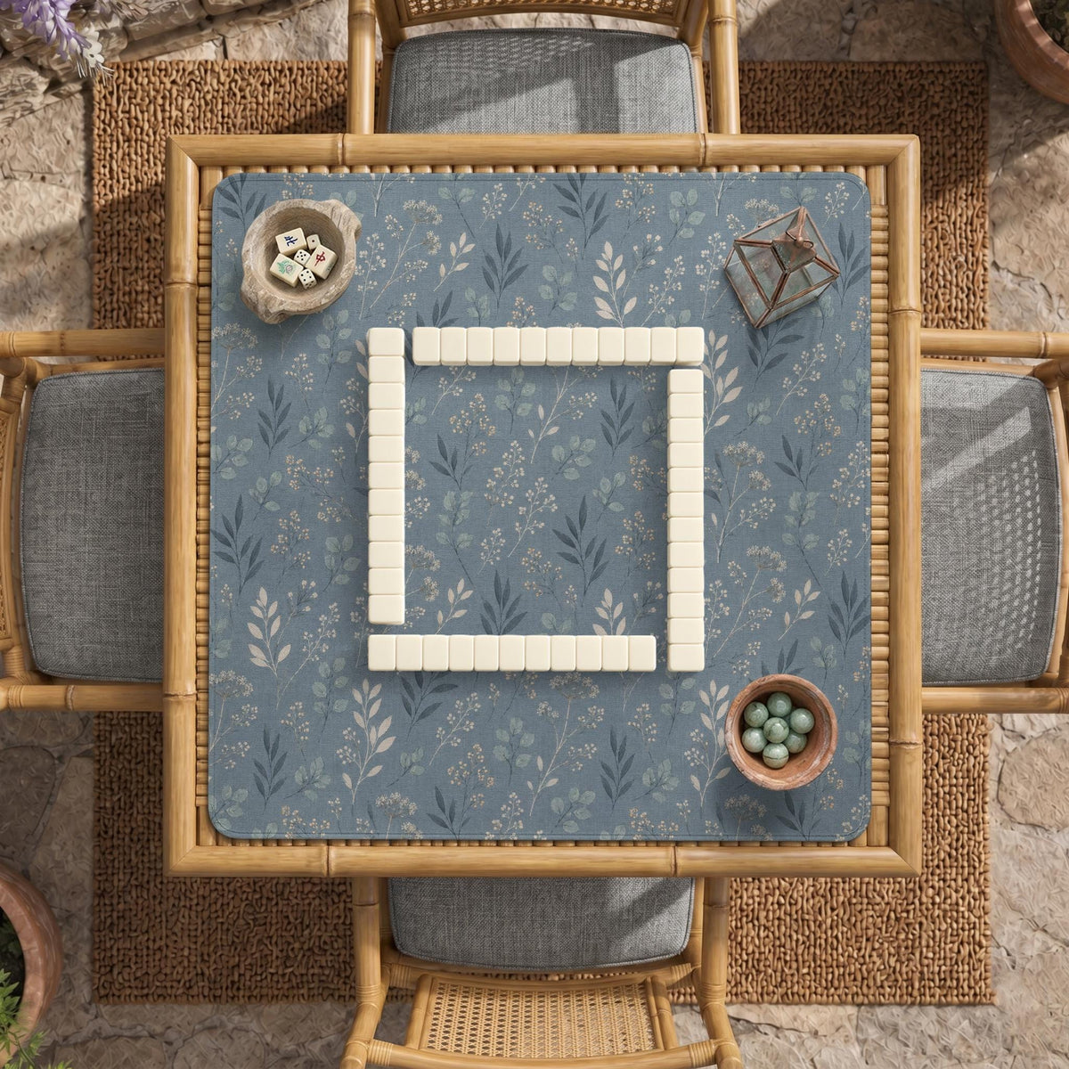Blue mahjong mat with a dusty linen-look background and small leafy botanical stems in a floral pattern.