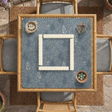 Blue mahjong mat with a botanical floral pattern, pale leaves, and delicate stems on a dusty blue background.