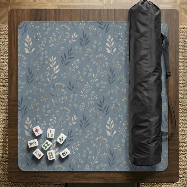 Blue mahjong mat with a dusty linen-look background and small leafy botanical stems in a floral pattern.