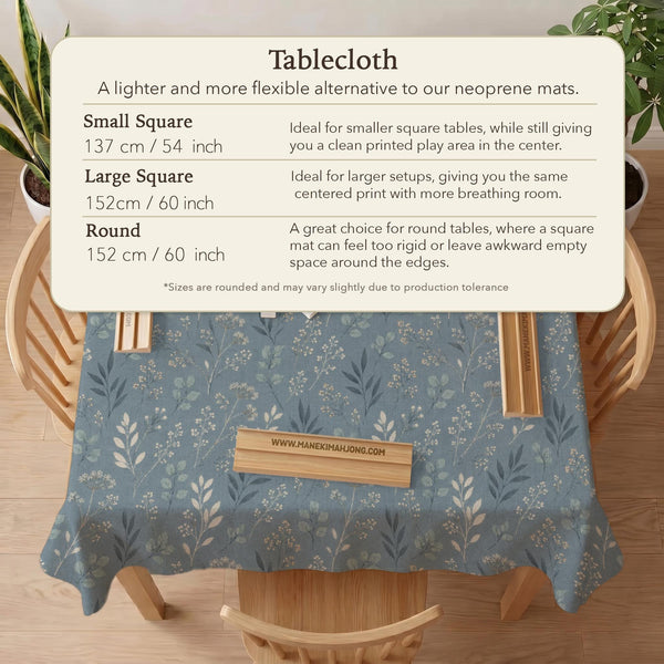 Blue mahjong mat with a dusty linen-look background and small leafy botanical stems in a floral pattern.