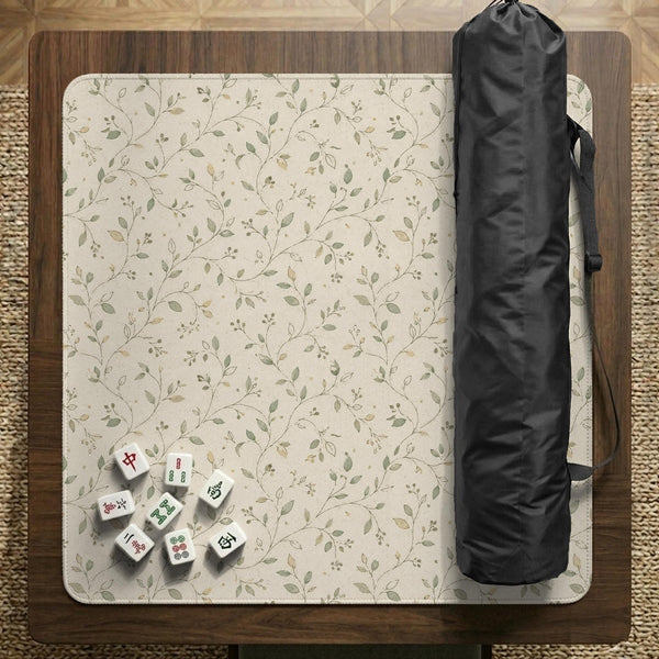 Sage green botanical mahjong mat with a cream background, trailing vines, and muted leaf designs.