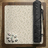 Cream square mahjong mat with a sage vine and leaf botanical pattern and scalloped edges.