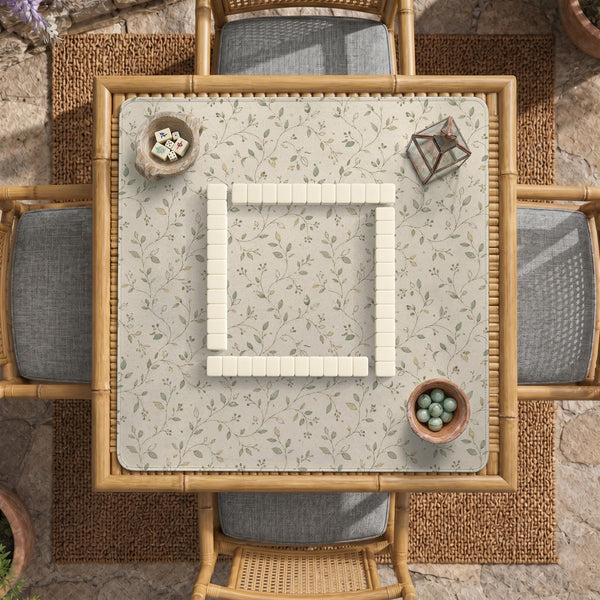 Sage green botanical mahjong mat with a cream background, trailing vines, and muted leaf designs.