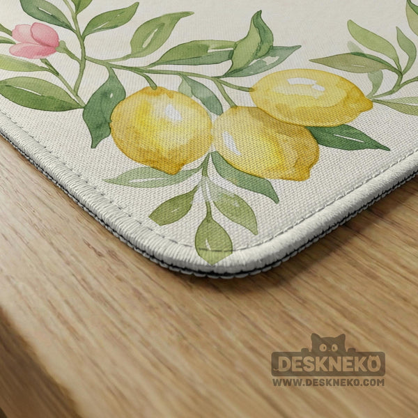 Square yellow mahjong mat with a citrus garden border, green vines, pink blossoms, aqua accents, and a plain center play area.