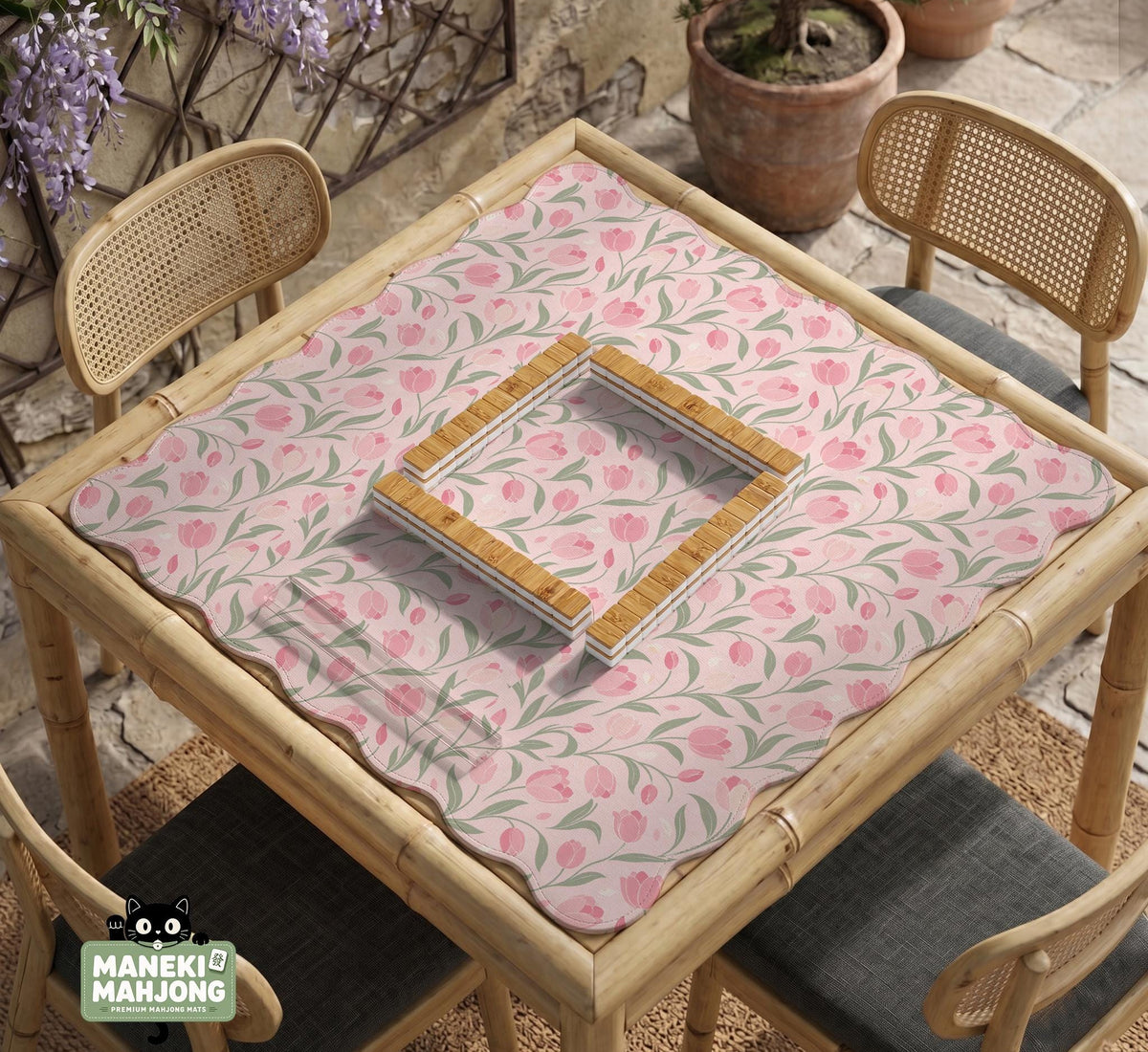A pink mahjong mat with tulip flowers, sage leaves, and a light pastel background.