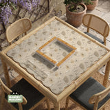 Neutral floral mahjong mat with delicate botanical line art and a scalloped edge on a cream background.