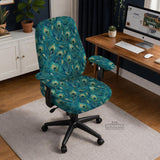 A blue green chair cover with a peacock feather design shown on an office chair with armrests.