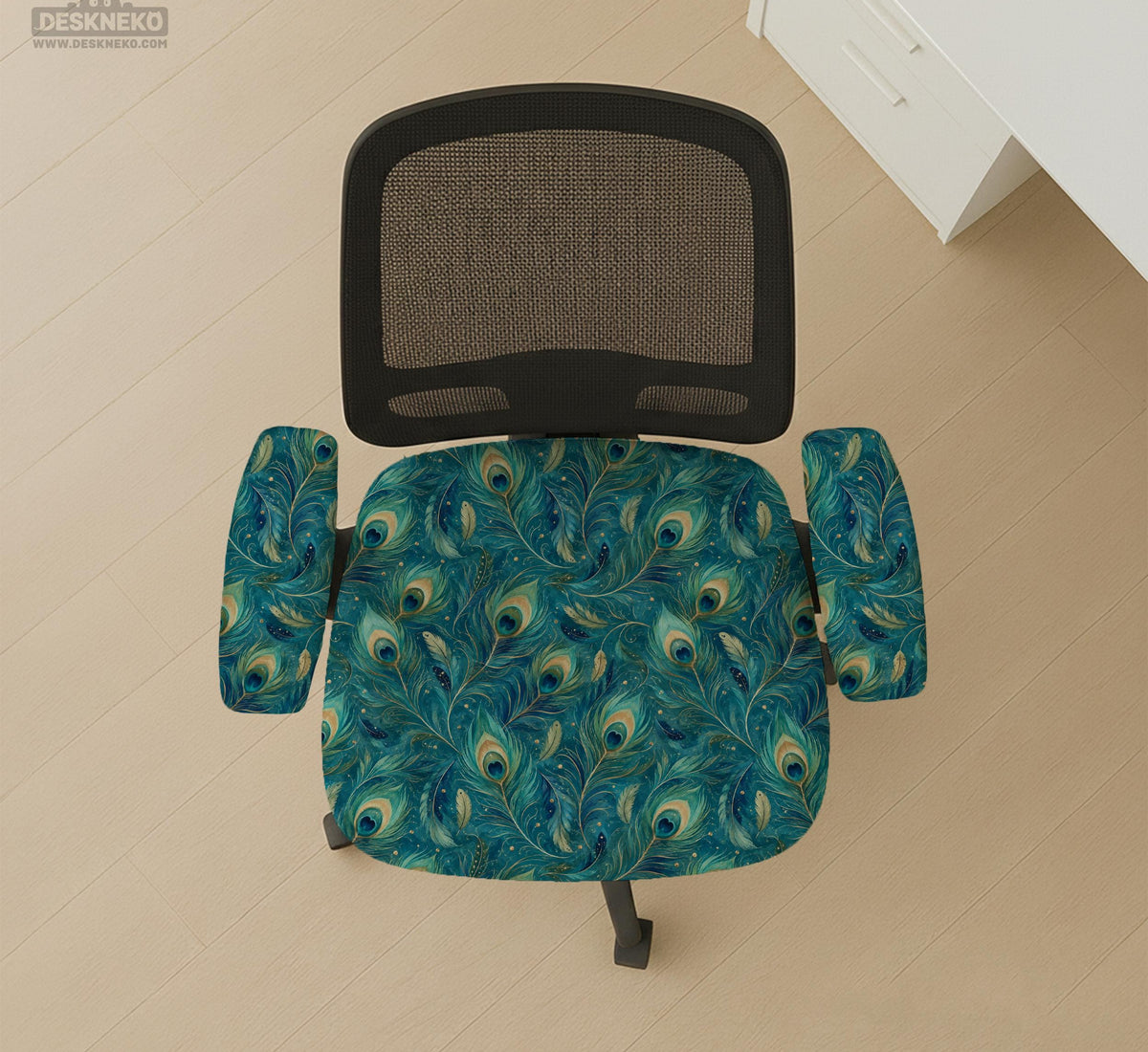 A blue green chair cover with a peacock feather design shown on an office chair with armrests.