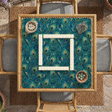 A teal mahjong mat with a peacock feather pattern and scalloped edges.