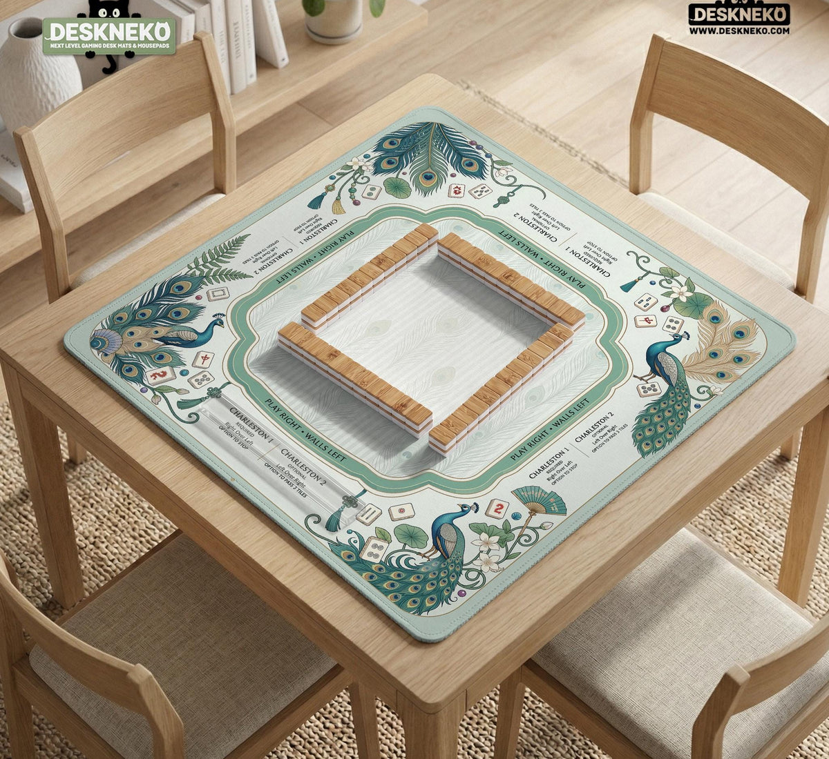 Teal square mahjong mat with peacock feathers, soft floral pattern, tassel details, and printed rule guide text in the center.