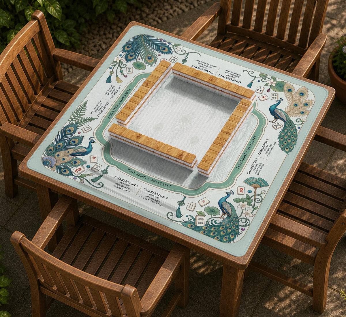 Teal square mahjong mat with peacock feathers, soft floral pattern, tassel details, and printed rule guide text in the center.
