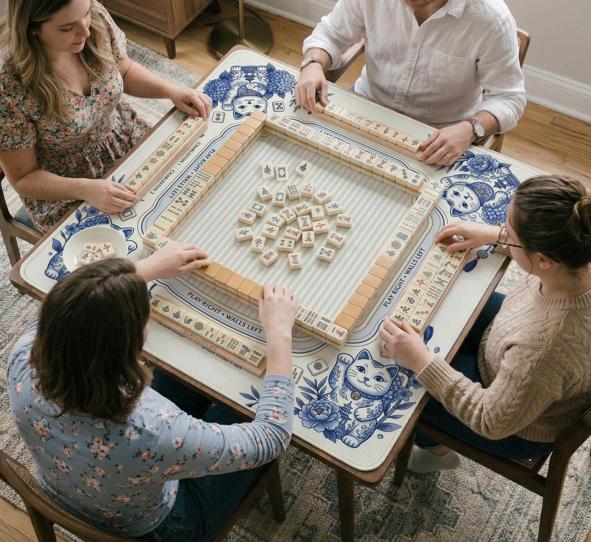 Blue and white square mahjong mat with lucky cat artwork, floral chinoiserie pattern, tile icons, and a rule guide layout.