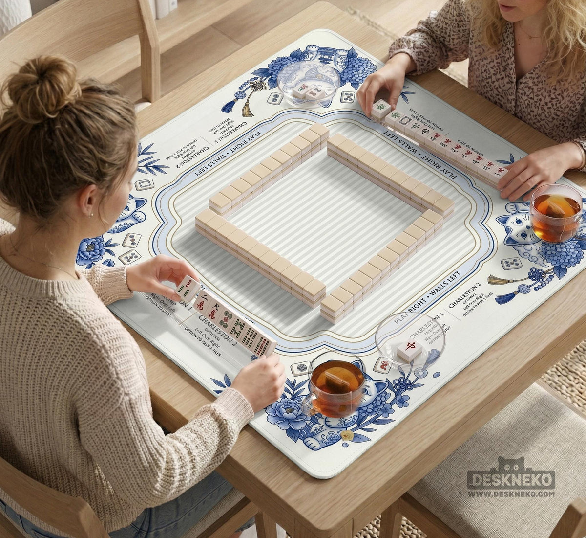 Blue and white square mahjong mat with lucky cat artwork, floral chinoiserie pattern, tile icons, and a rule guide layout.
