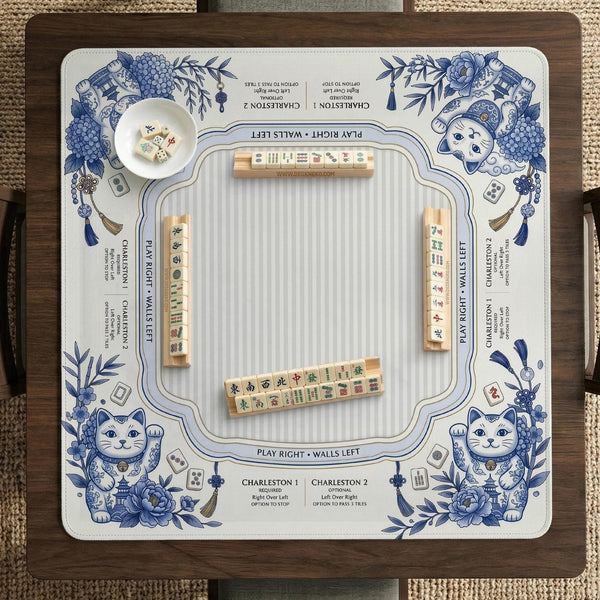 Blue and white square mahjong mat with lucky cat artwork, floral chinoiserie pattern, tile icons, and a rule guide layout.