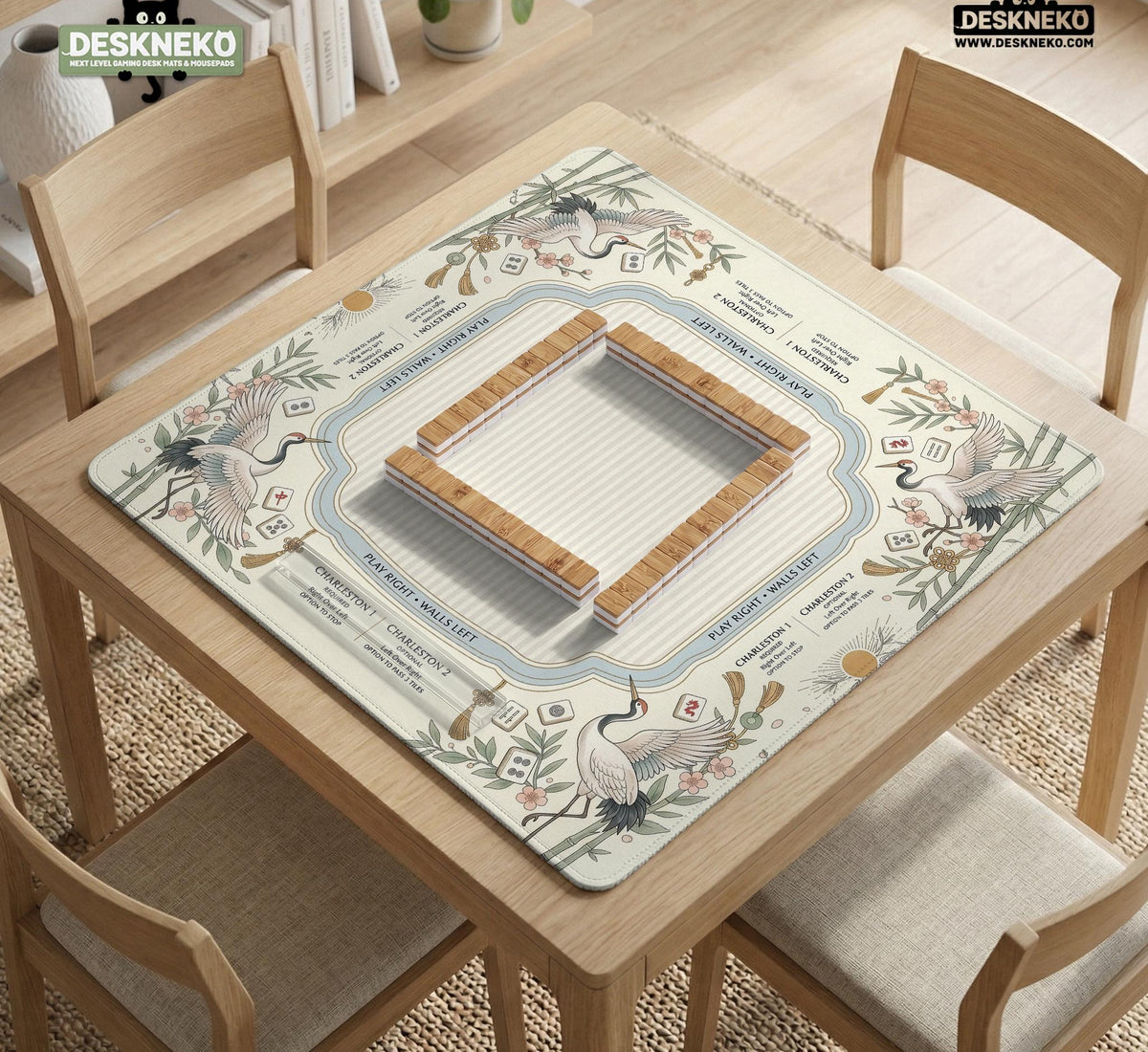 Beige square mahjong mat with a sage border, crane birds, bamboo, flowers, tile icons, and printed rules around a clean center play area.