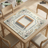 Beige square mahjong mat with a sage border, crane birds, bamboo, flowers, tile icons, and printed rules around a clean center play area.