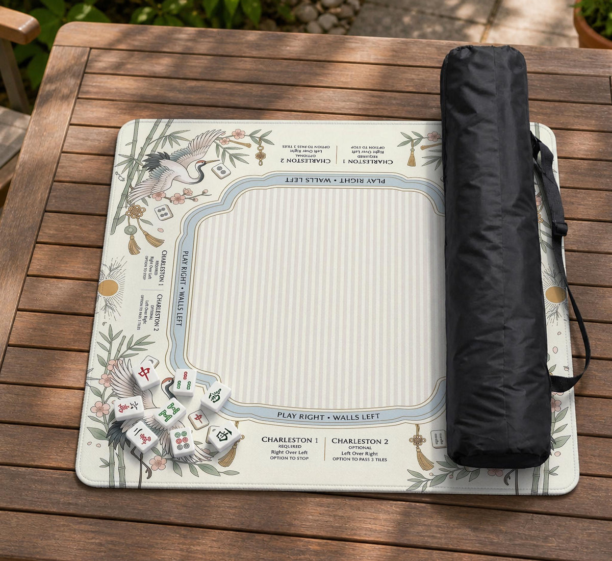 Beige square mahjong mat with a sage border, crane birds, bamboo, flowers, tile icons, and printed rules around a clean center play area.