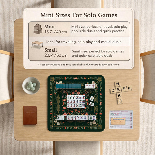 Dark botanical mahjong table mat with a floral border, large moth and butterfly design in the center, gold corner frame, and printed rules layout around the edge.