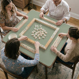 A plain light sage green square mahjong mat with a smooth solid-color surface.