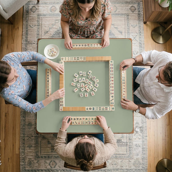 A plain light sage green square mahjong mat with a smooth solid-color surface.