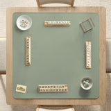 A plain light sage green square mahjong mat with a smooth solid-color surface.