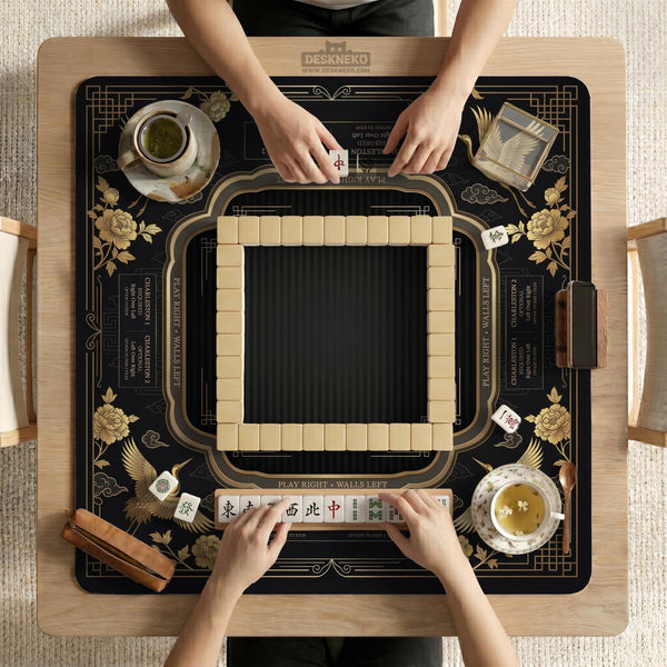 Black and gold square mahjong mat with an art deco crane and floral border, rule reminders around the edges, and a blank center area.