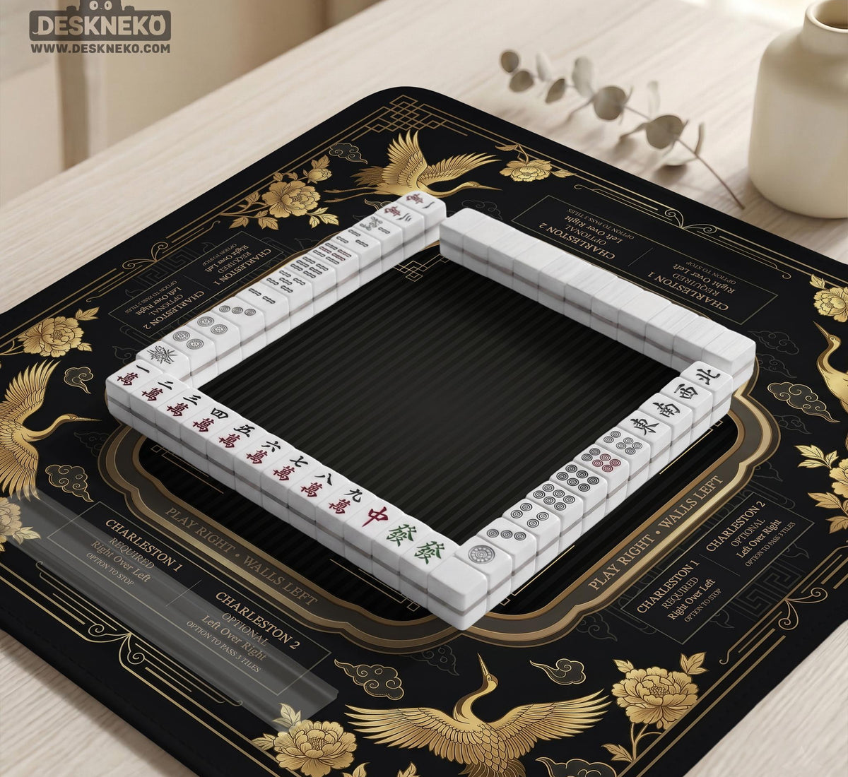 Black and gold square mahjong mat with an art deco crane and floral border, rule reminders around the edges, and a blank center area.