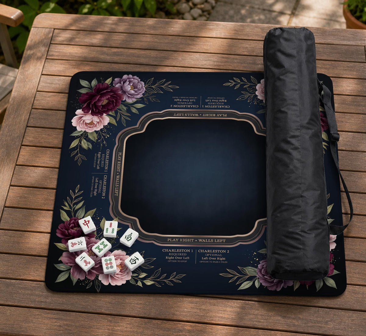 Burgundy mahjong mat with a floral border, gold botanical details, and printed American Mahjong rules on a dark background.