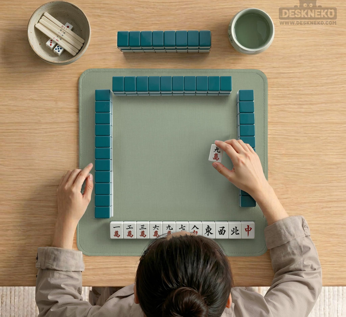 A square sage green mahjong mat with scalloped edges on a plain background.