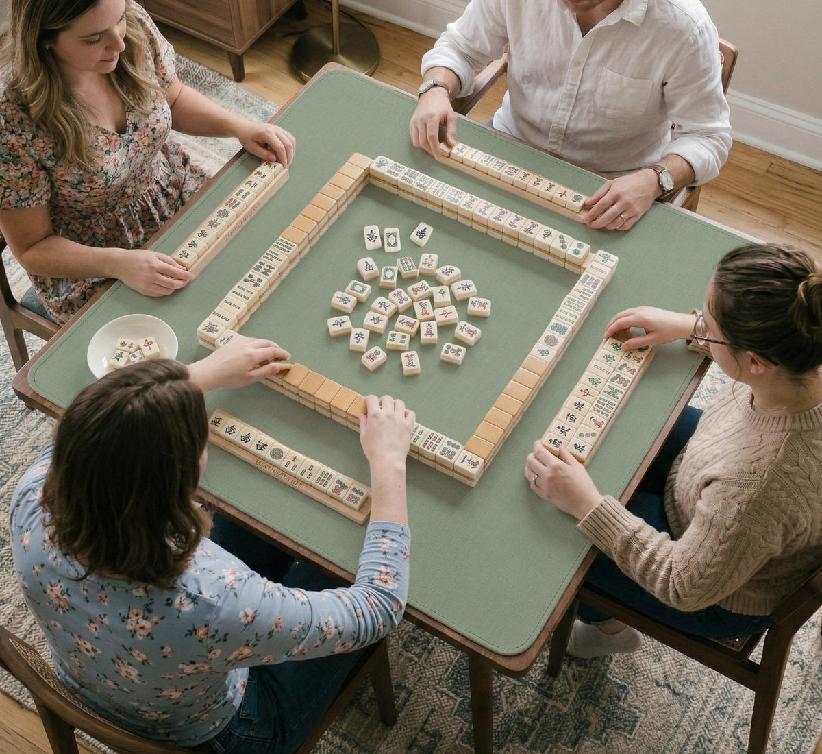 A square sage green mahjong mat with scalloped edges on a plain background.