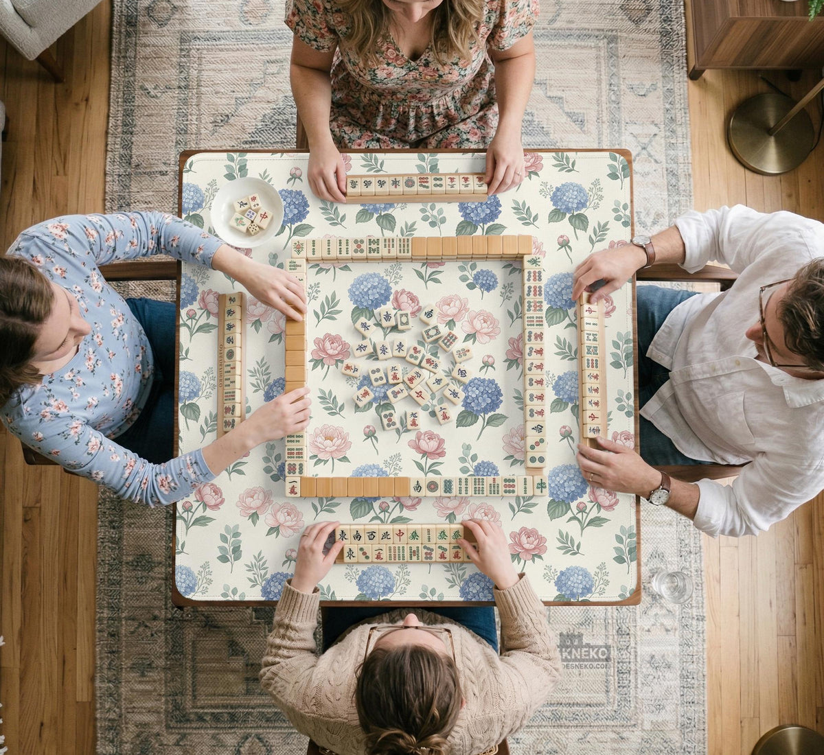 Pink floral mahjong table mat with peonies, blue hydrangeas, sage green leaves, and an ivory background.