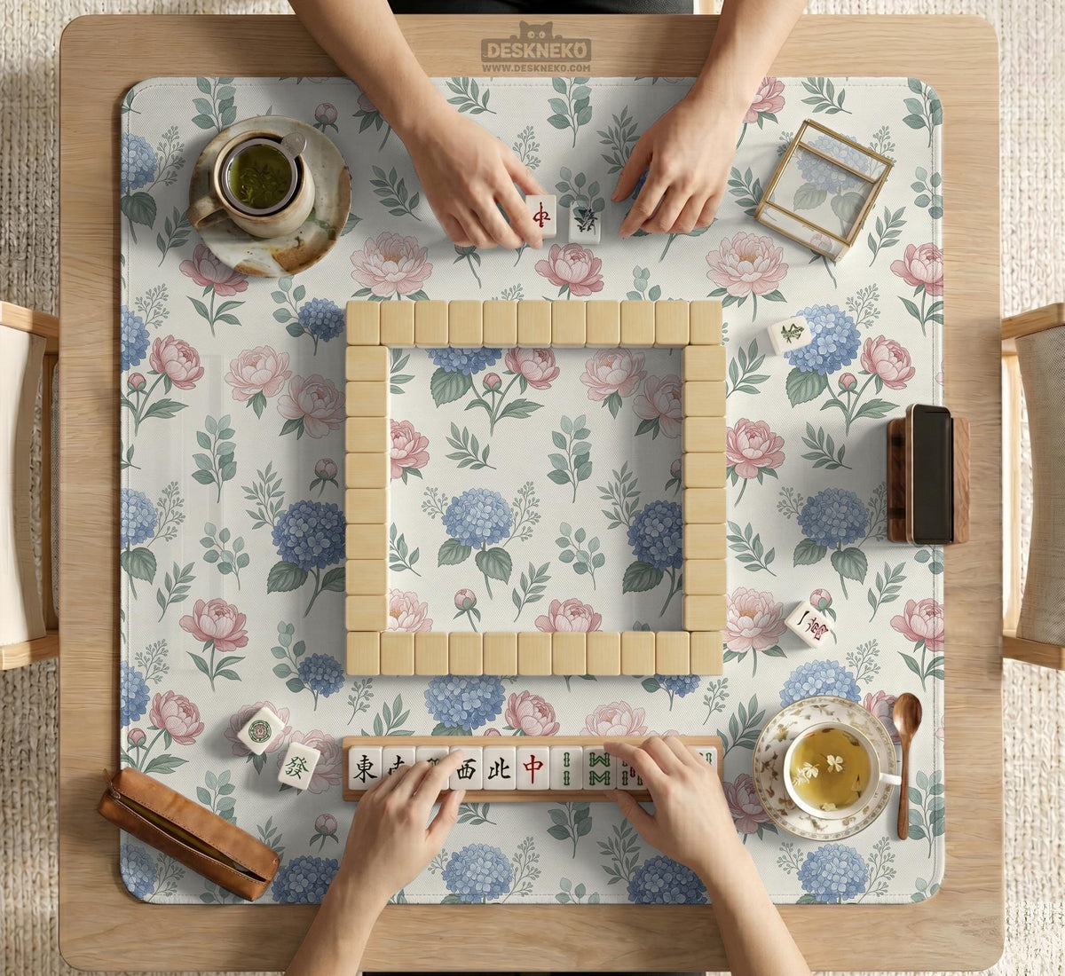 Pink floral mahjong table mat with peonies, blue hydrangeas, sage green leaves, and an ivory background.