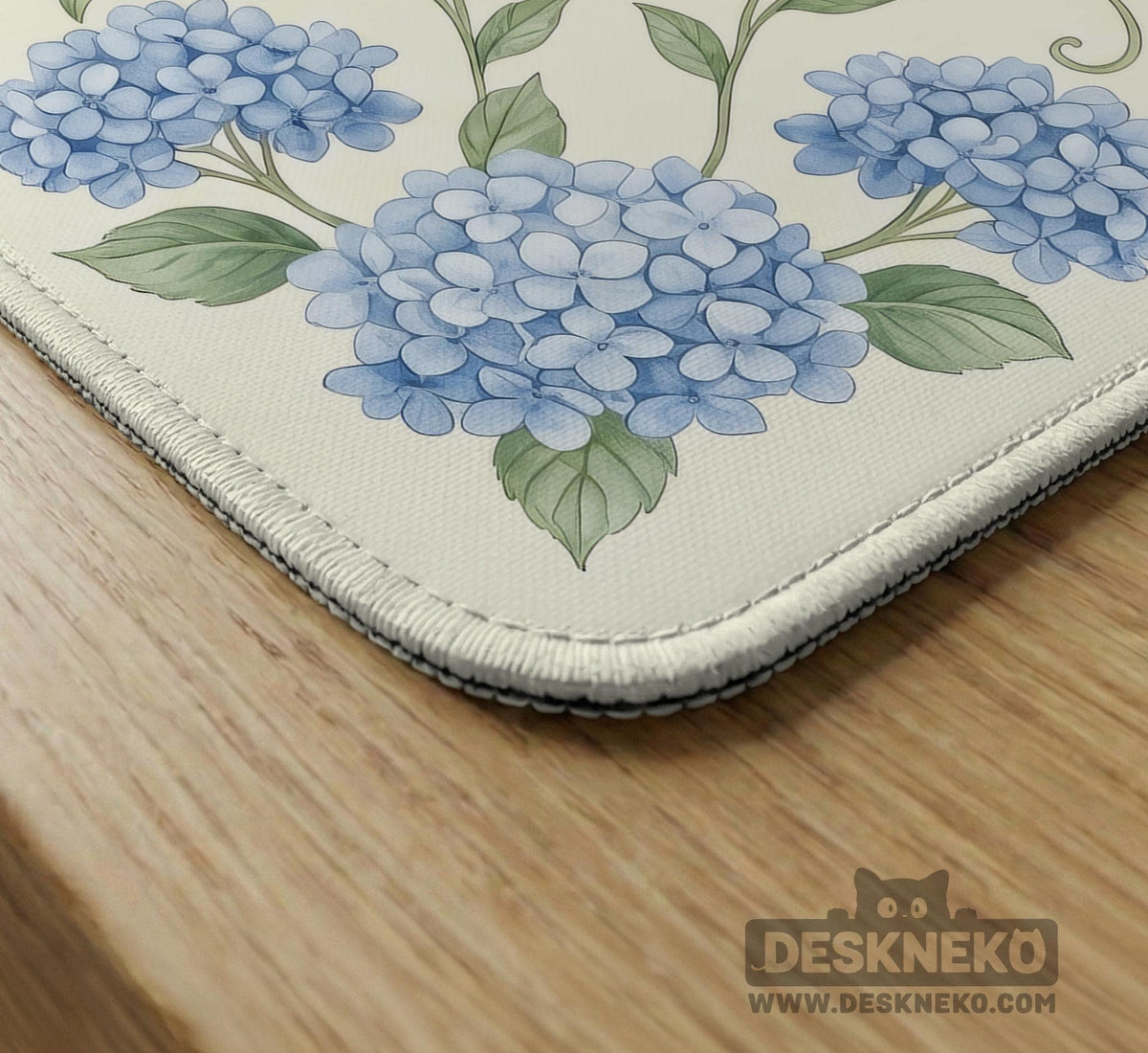 A square mahjong mat with blue hydrangea flowers, green vines, a cream background, a striped center, and printed rules around the border.