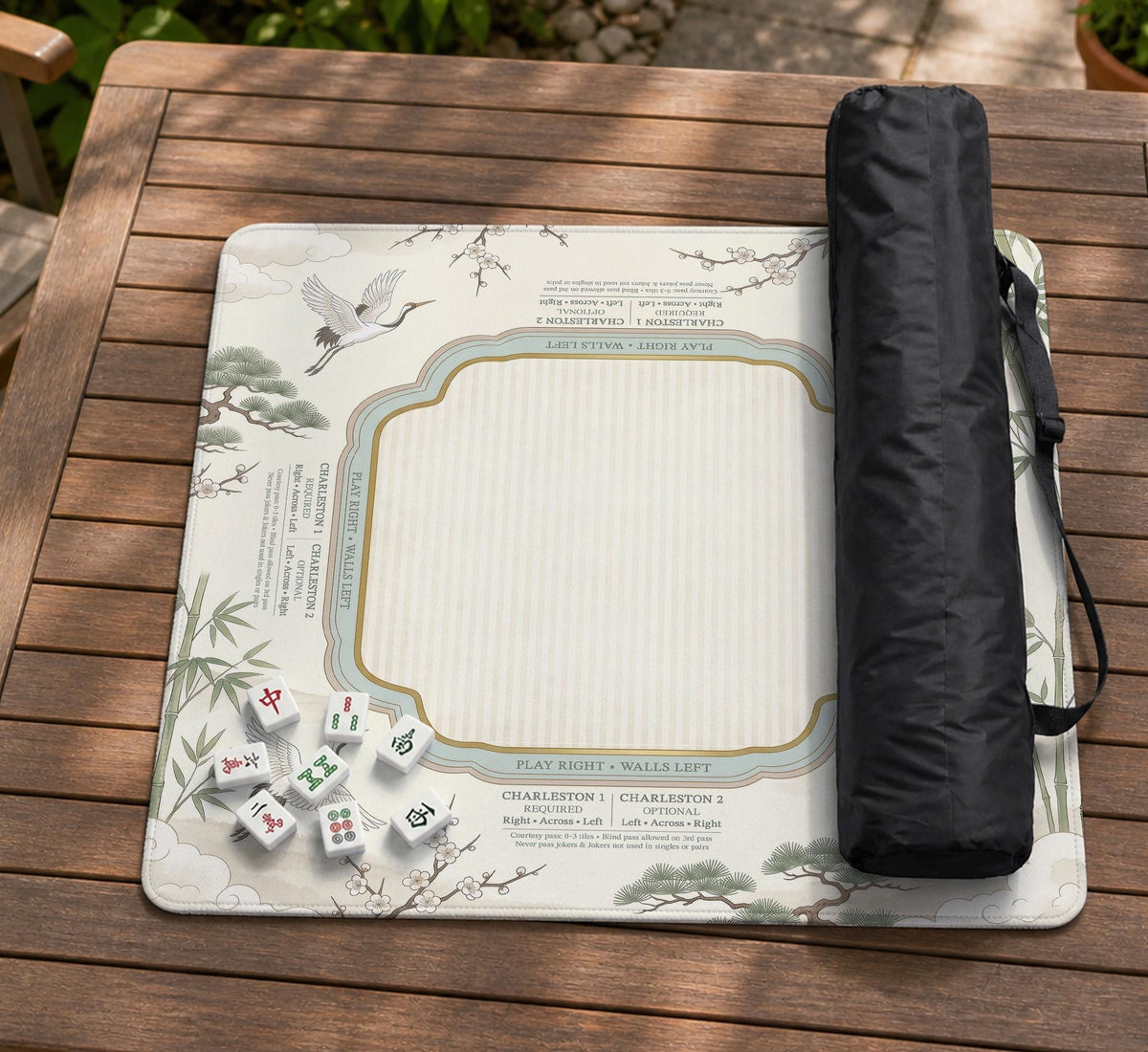 Sage green scalloped mahjong mat with bamboo, crane, and blossom illustration and printed rules around the border.