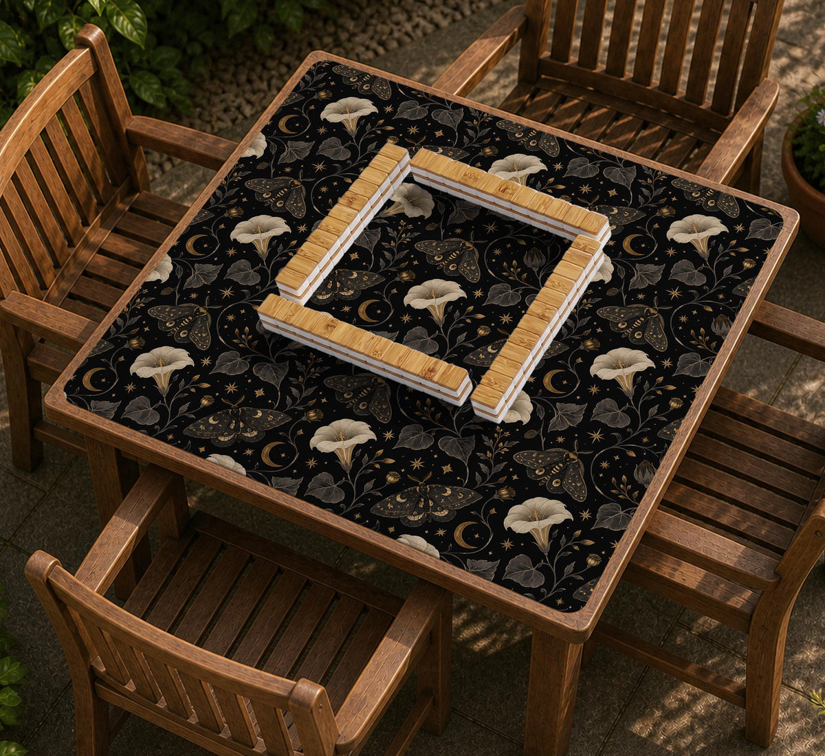 Black square mahjong mat with moths, moonflowers, crescent moons, and scattered stars in a celestial floral pattern.