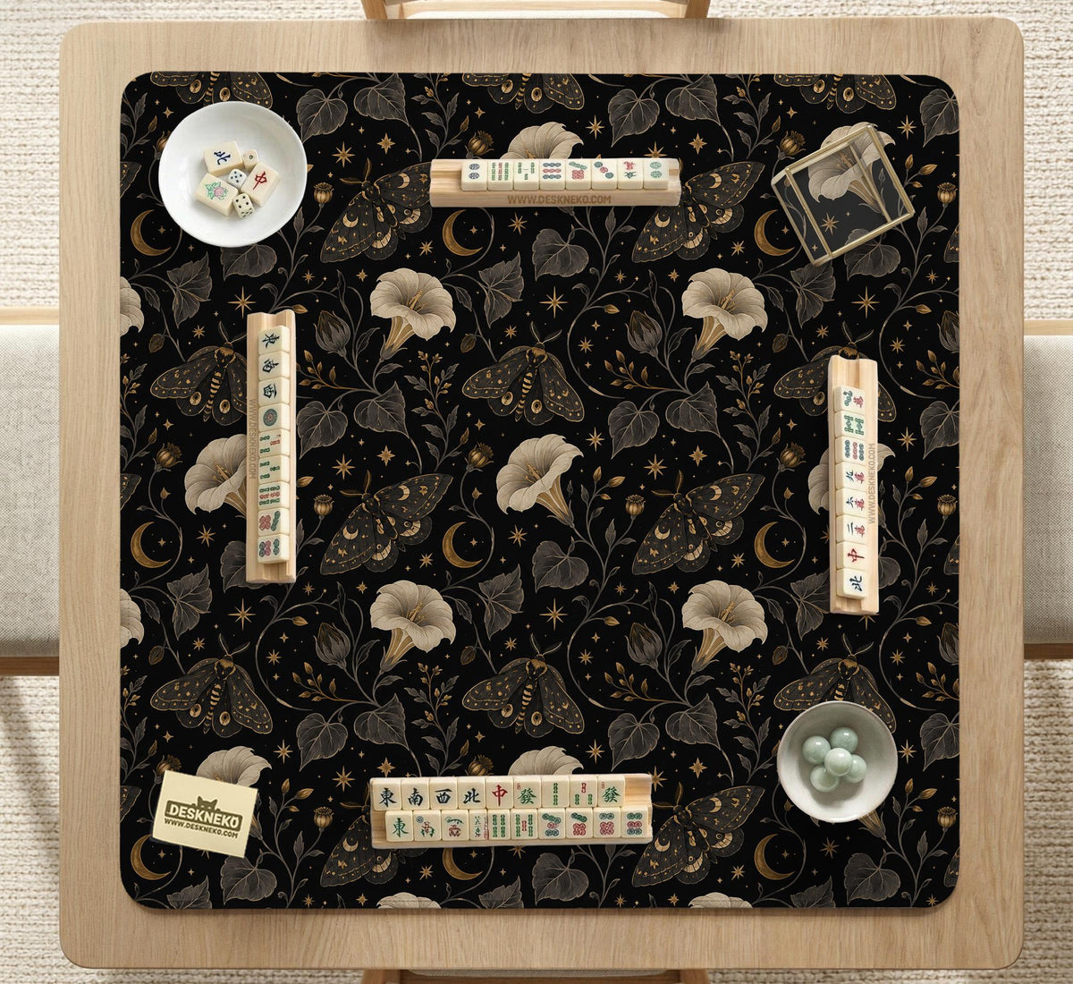 Black square mahjong mat with moths, moonflowers, crescent moons, and scattered stars in a celestial floral pattern.