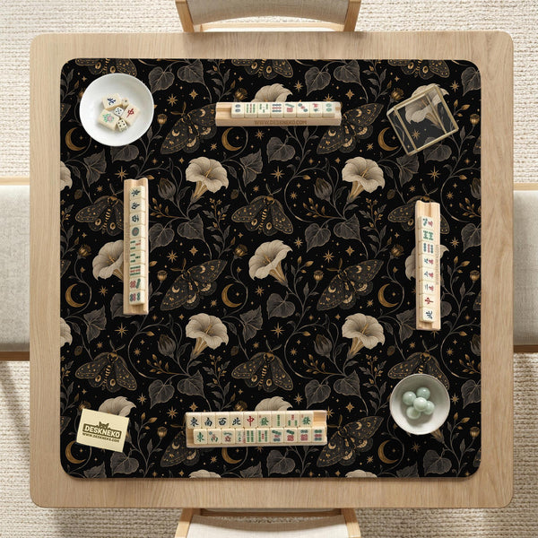 Black square mahjong mat with moths, moonflowers, crescent moons, and scattered stars in a celestial floral pattern.