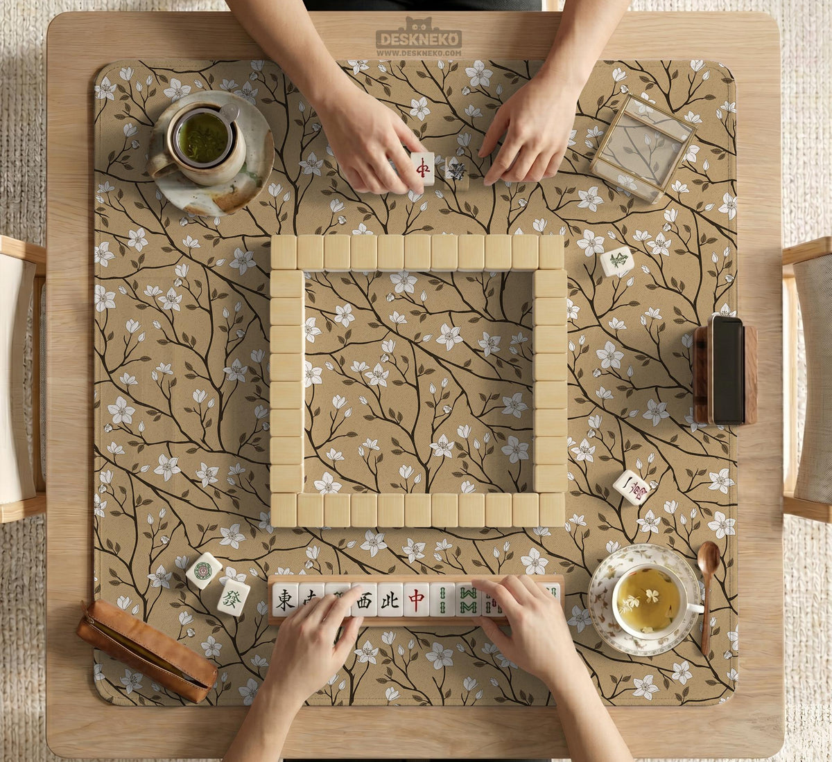 Beige mahjong mat with a white blossom branch floral pattern on a neutral background.