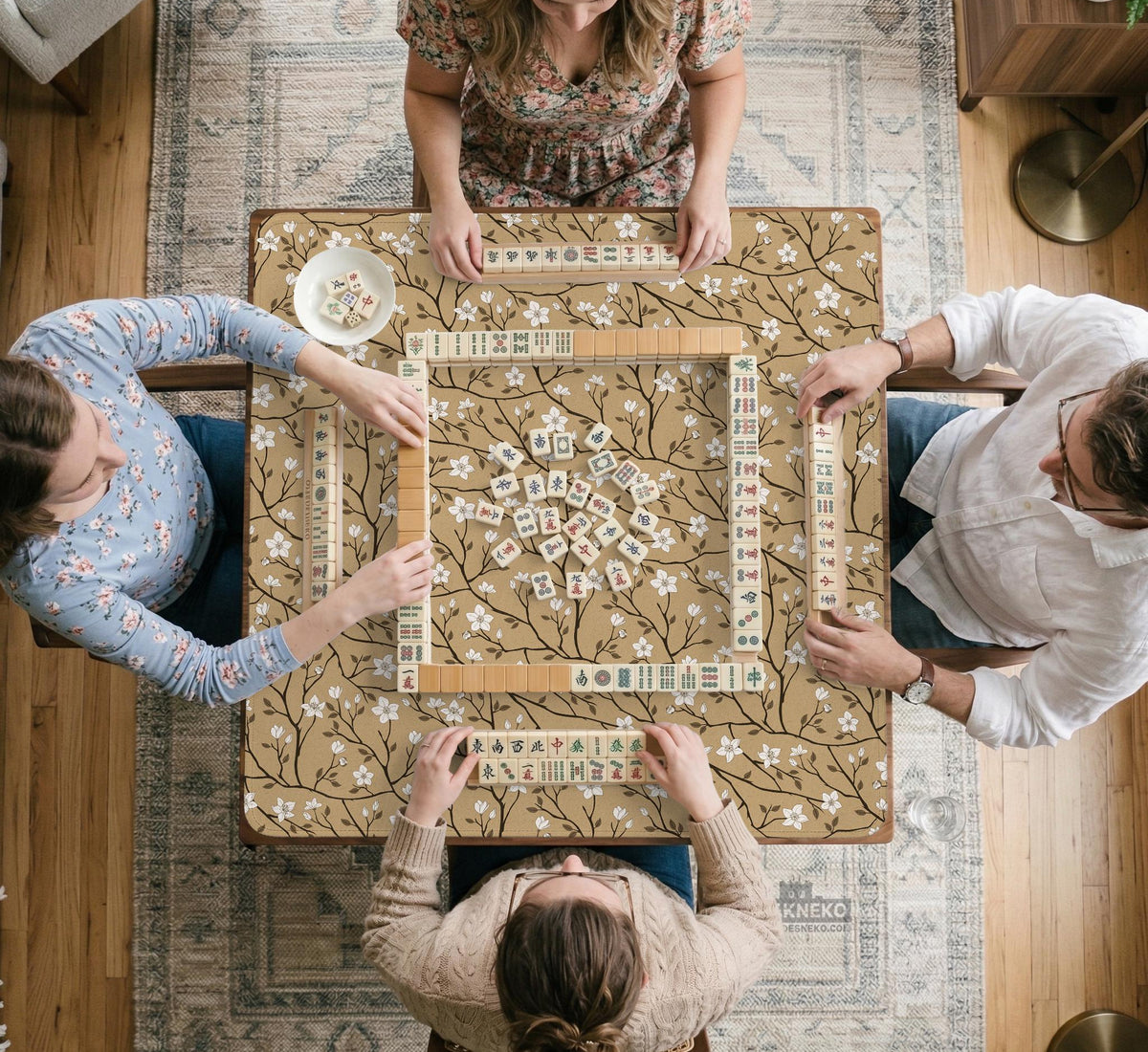 Beige mahjong mat with a white blossom branch floral pattern on a neutral background.