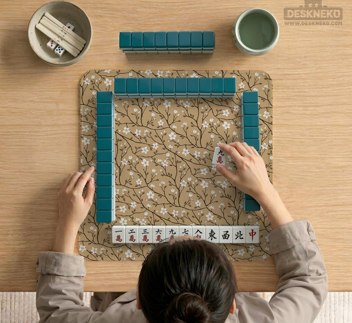 Beige mahjong mat with a white blossom branch floral pattern on a neutral background.