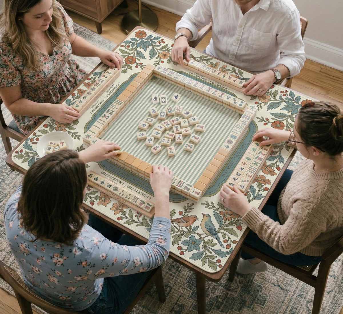 Square mahjong mat with a cream background, blue birds, sage leaves, terracotta flowers, and a decorative botanical border with printed rules text.