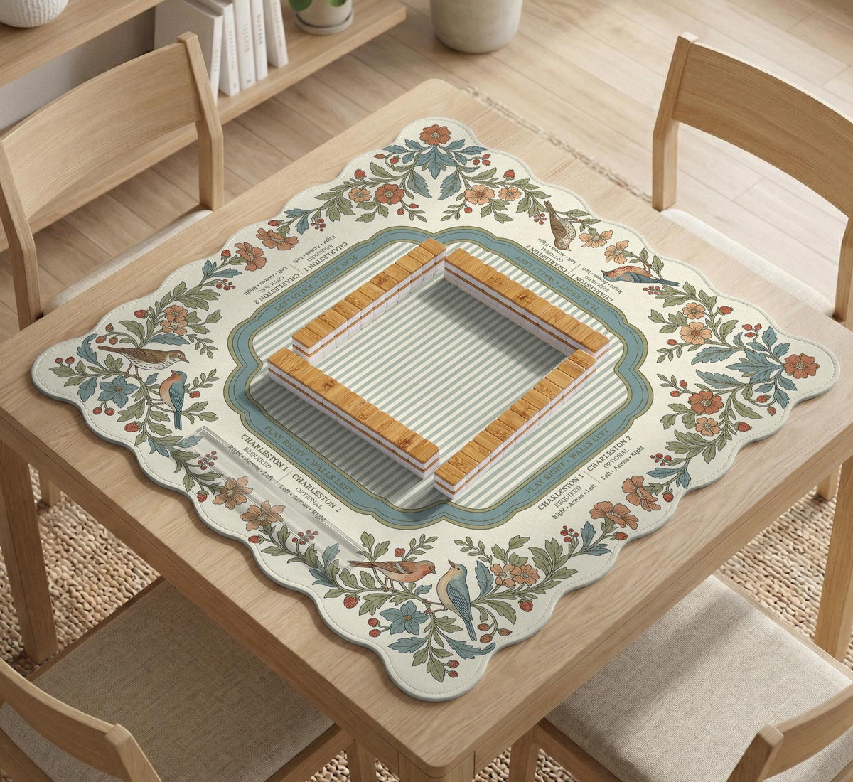 Square mahjong mat with a cream background, blue birds, sage leaves, terracotta flowers, and a decorative botanical border with printed rules text.