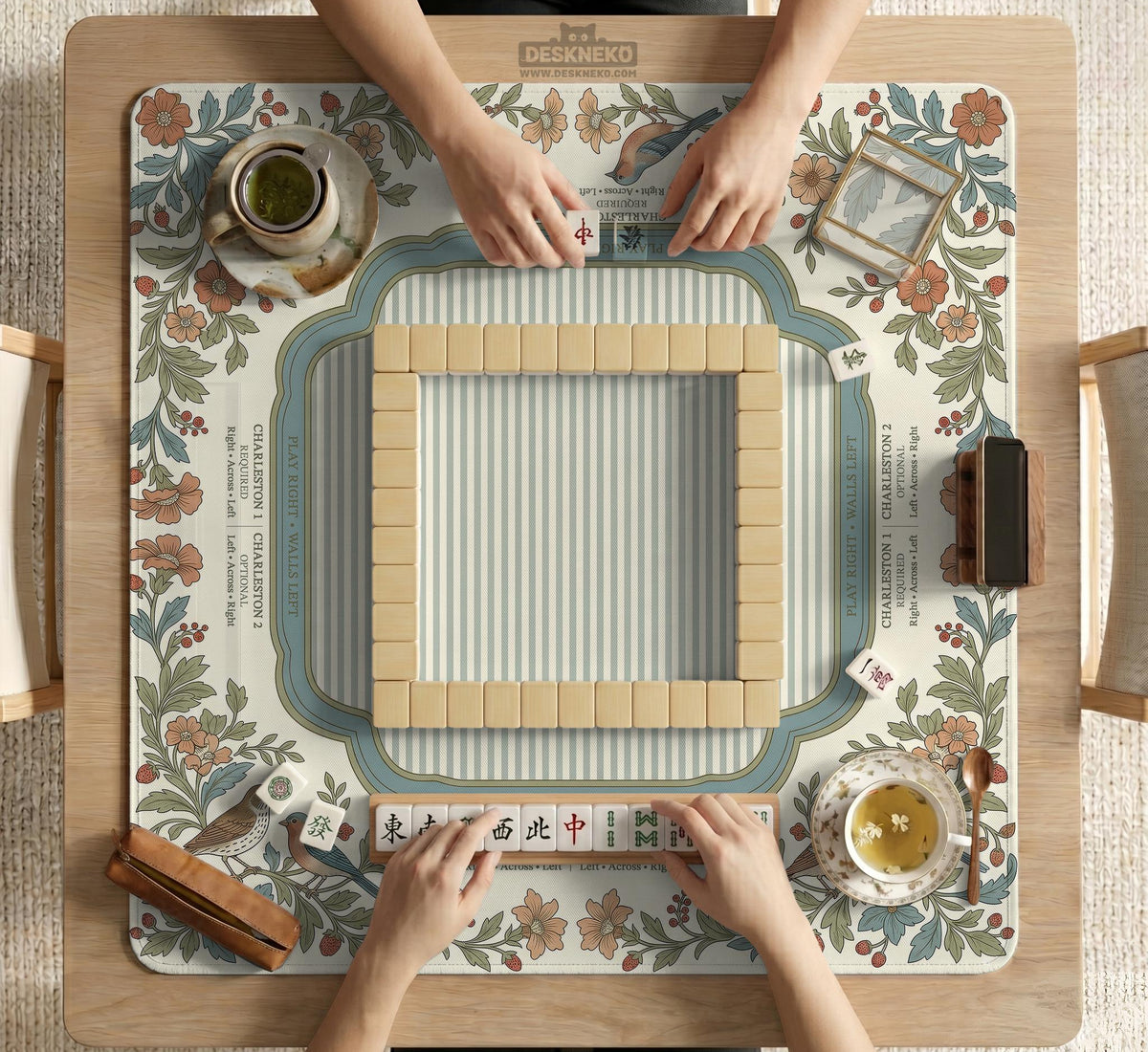 Square mahjong mat with a cream background, blue birds, sage leaves, terracotta flowers, and a decorative botanical border with printed rules text.