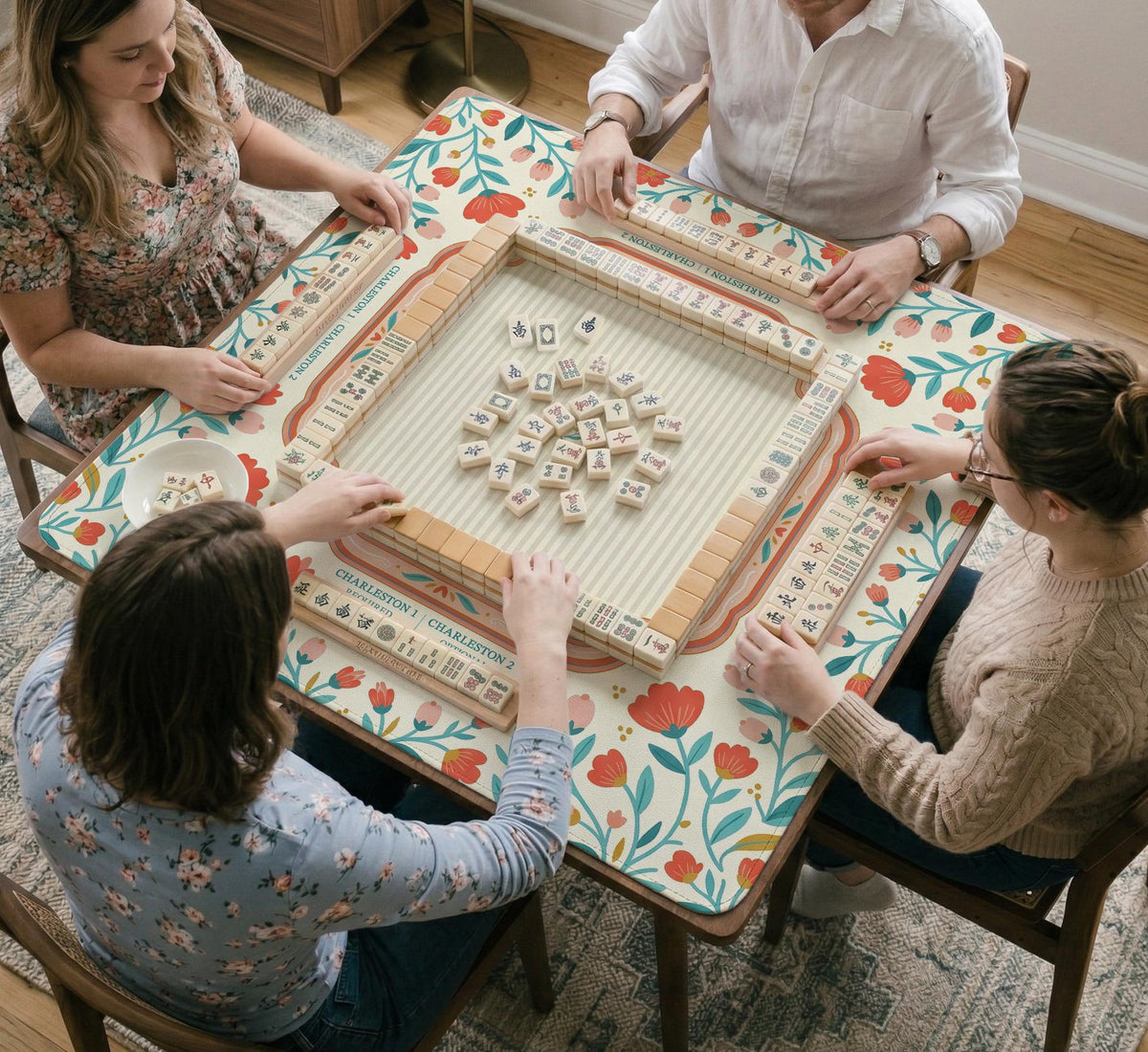 Cream mahjong mat with a coral and teal floral border, rule layout text, Charleston guide notes, and a blank center area for tile play.