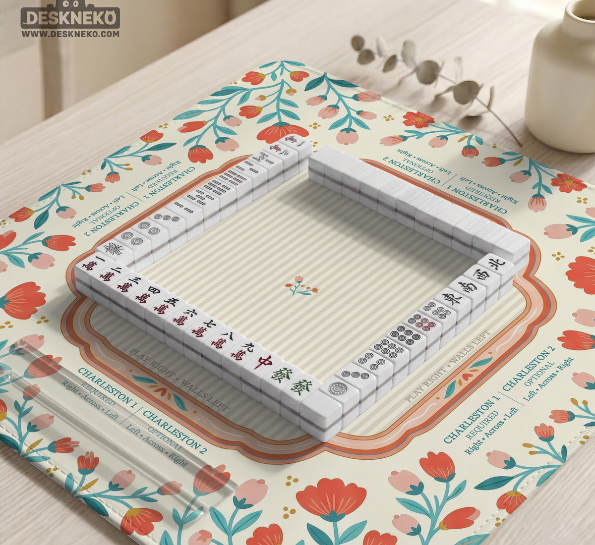 Cream mahjong mat with a coral and teal floral border, rule layout text, Charleston guide notes, and a blank center area for tile play.