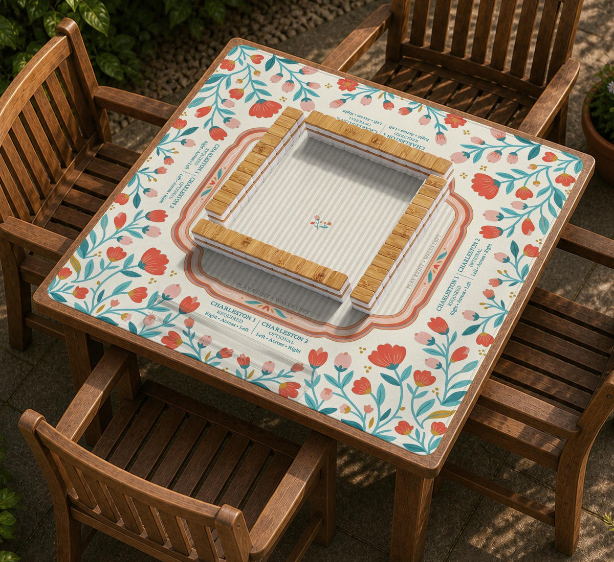 Cream mahjong mat with a coral and teal floral border, rule layout text, Charleston guide notes, and a blank center area for tile play.