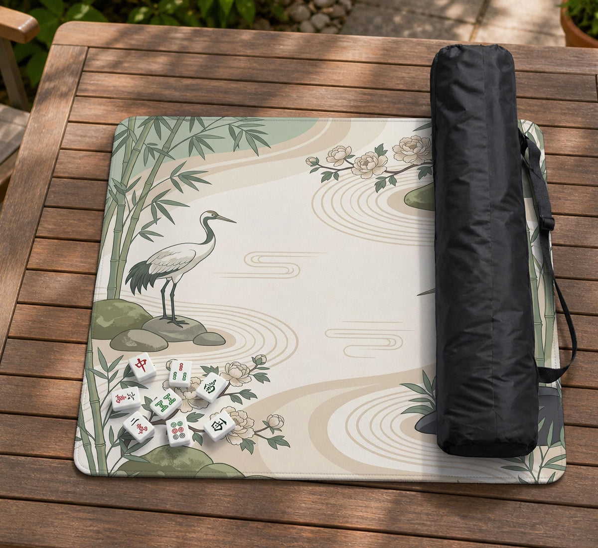 Square mahjong mat with a cream background, sage green cranes, bamboo leaves, peony branches, stones, and thin linework.